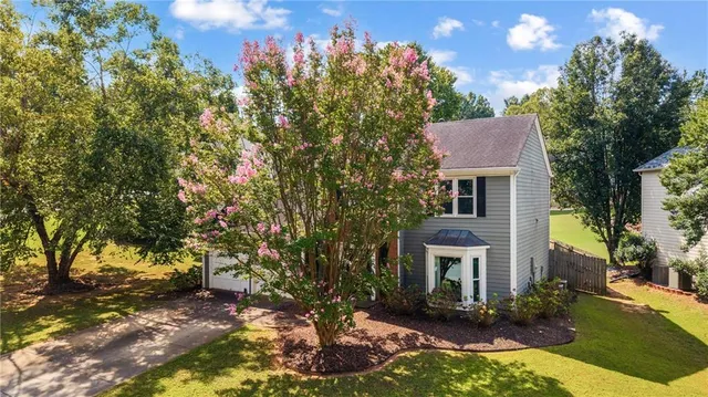a front view of a house with yard and trees