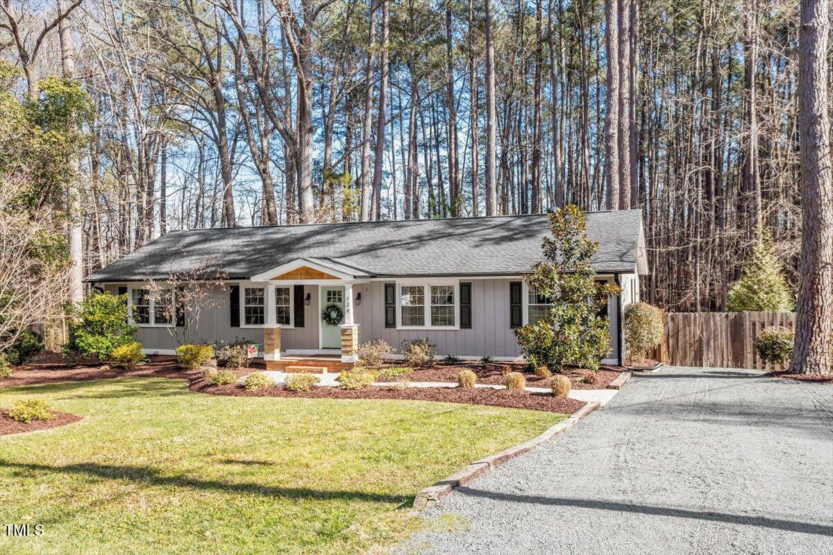 a front view of a building with garden and trees