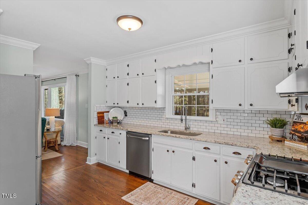 134 Landsbury Drive Durham, NC 27707 - Photo 16 of 44 a kitchen with granite countertop a sink stove and cabinets