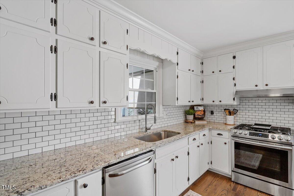 134 Landsbury Drive Durham, NC 27707 - Photo 19 of 44 a kitchen with granite countertop white cabinets stainless steel appliances and a sink
