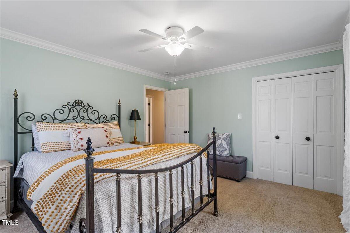 134 Landsbury Drive Durham, NC 27707 - Photo 32 of 44 a bedroom with a bed and a chandelier