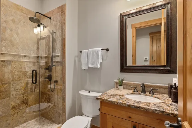 a bathroom with a granite countertop sink toilet and shower
