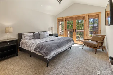 a bedroom with a bed and a couch next to a window