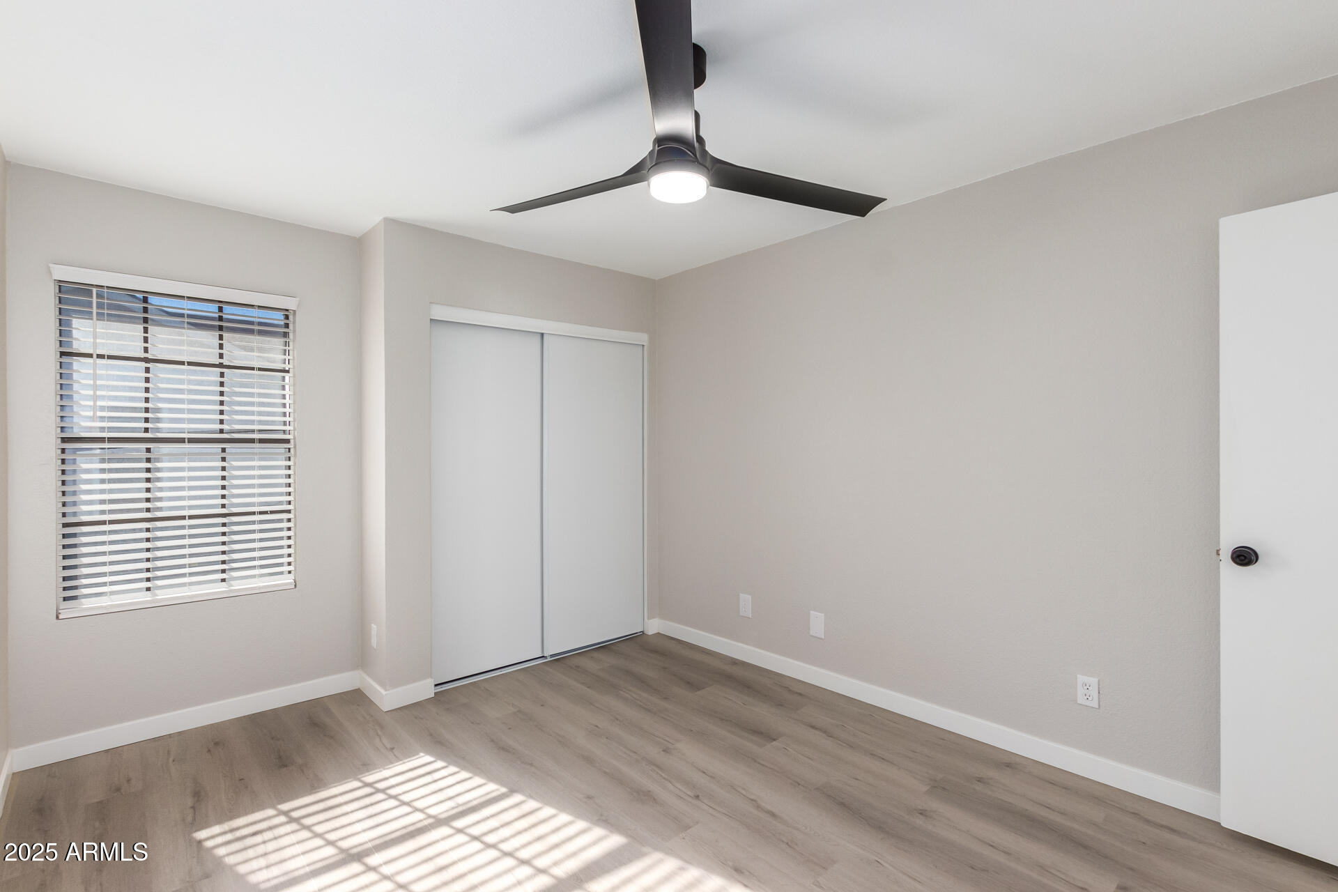 8888 North 47th Avenue, Unit 212 Glendale, AZ 85302 - Photo 11 of 18 a view of an empty room with wooden floor and a window