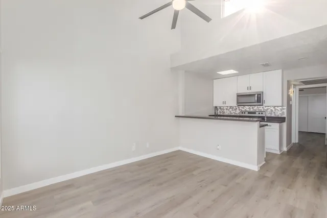 a view of kitchen with granite countertop cabinets and refrigerator