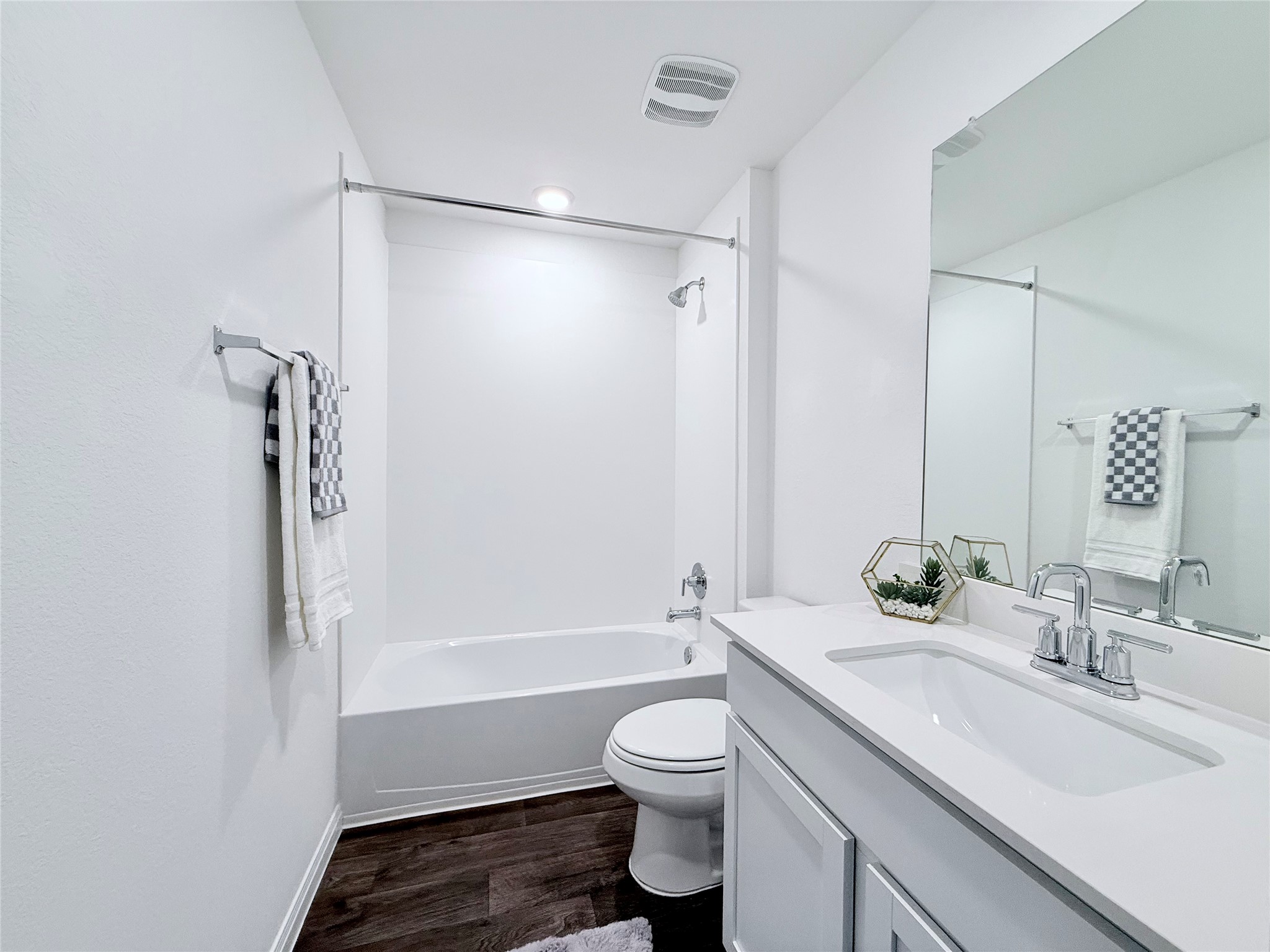 598 Gladiola Loop Kyle, TX 78640 - Photo 26 of 33 Bathroom with vanity, dark wood-style floors, and tub / shower combination