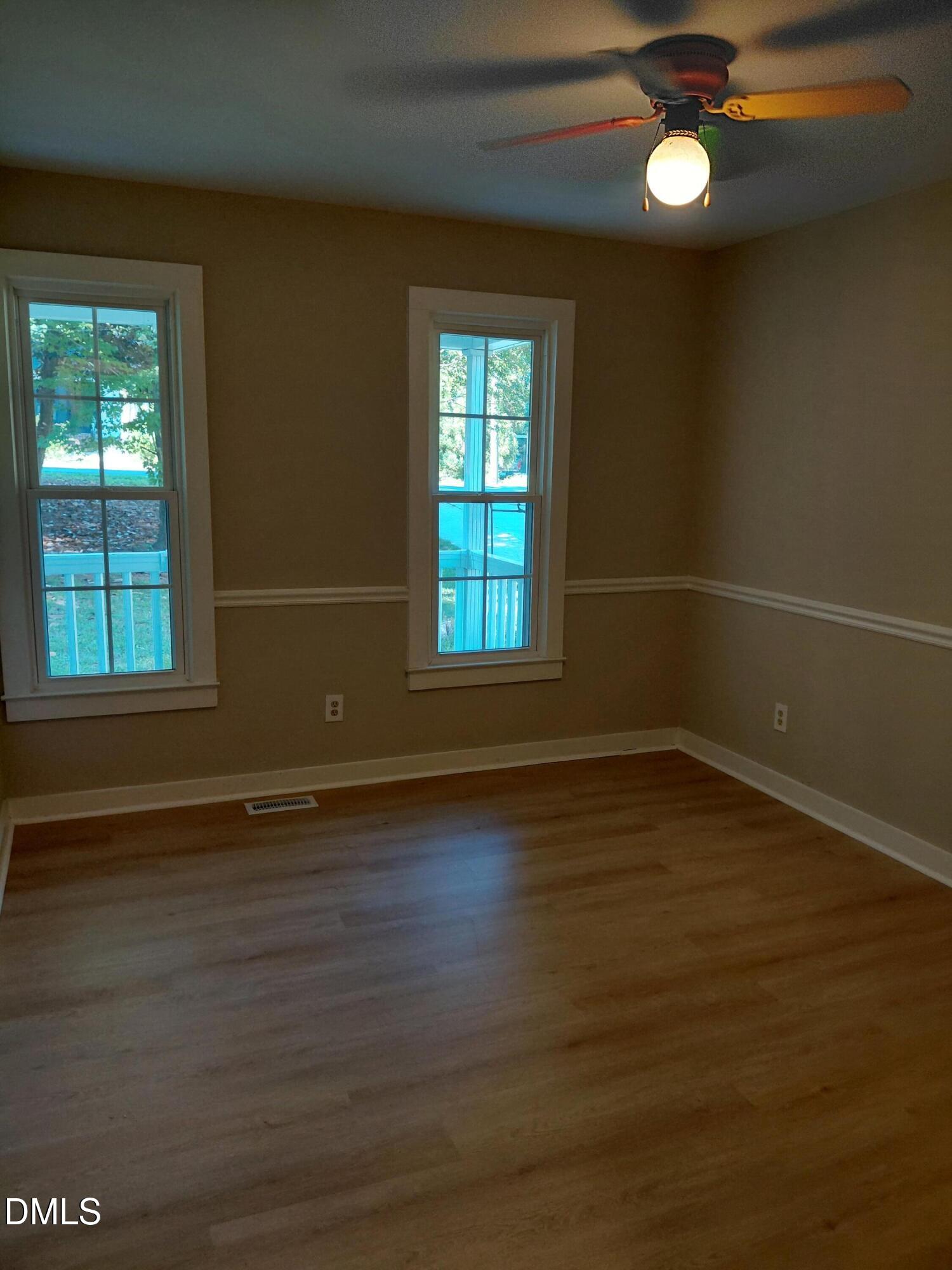 804 Olive Street Apex, NC 27502 - Photo 56 of 60 an empty room with wooden floor and windows