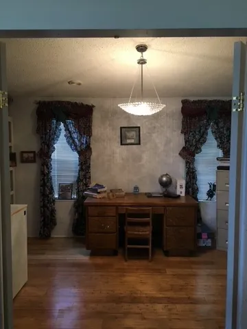 a kitchen with a refrigerator and a wooden floor