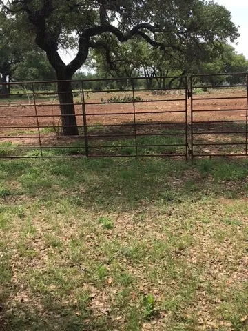 a view of a yard with wooden fence