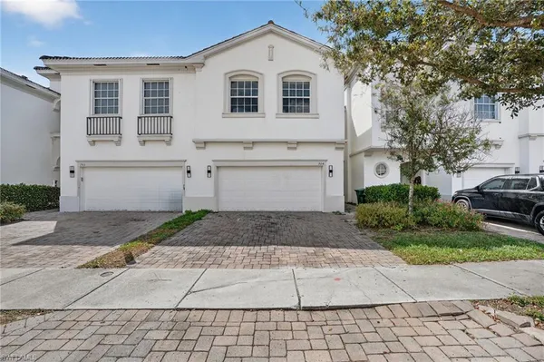 a view of a white house with a yard and garage