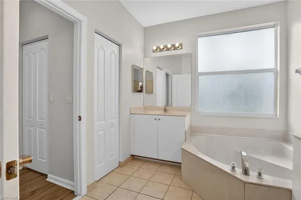 a bathroom with a tub sink and mirror