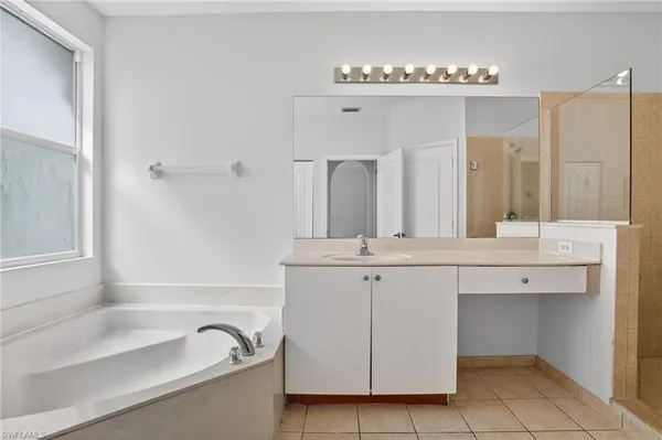 a bathroom with a tub sink and mirror