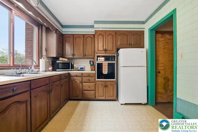 a kitchen with sink refrigerator and cabinets