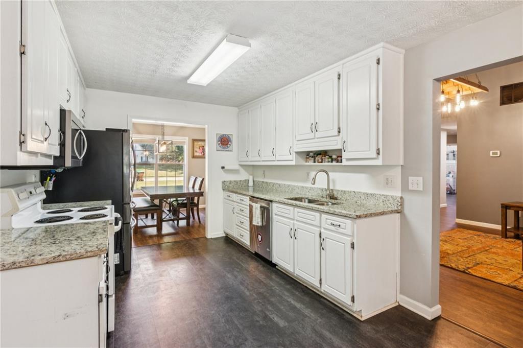 115 Alcovy Circle Covington, GA 30014 - Photo 11 of 27 a kitchen with granite countertop sink stove and cabinets