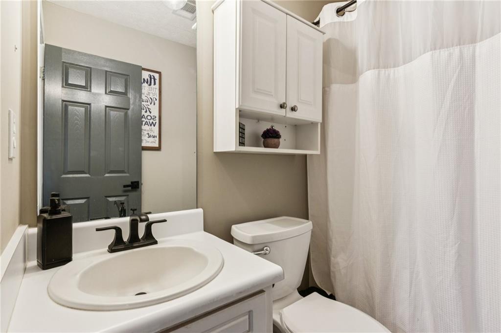 115 Alcovy Circle Covington, GA 30014 - Photo 20 of 27 a bathroom with a sink a toilet and shower curtain