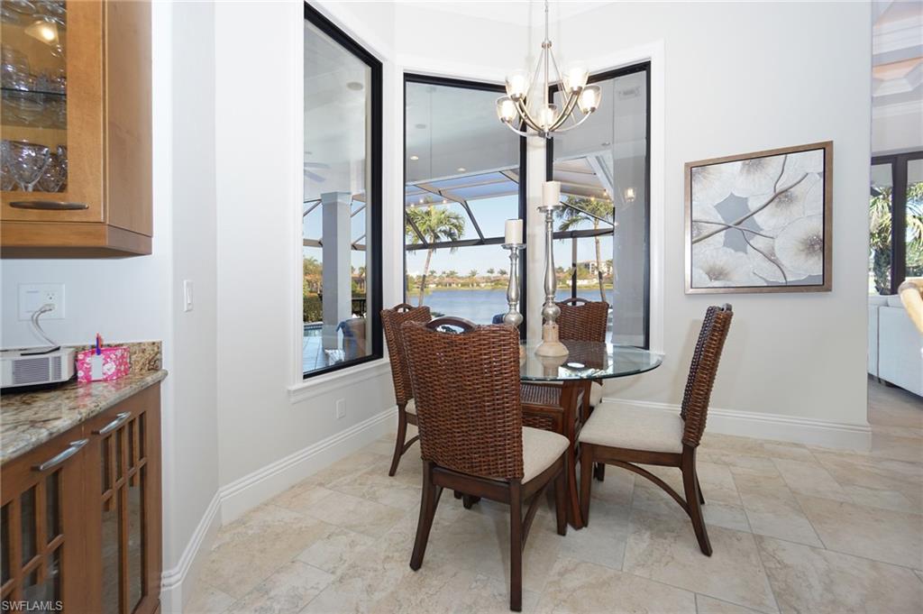 7316 Hagen Way Naples, FL 34113 - Photo 25 of 48 a dining room with furniture a chandelier and wooden floor