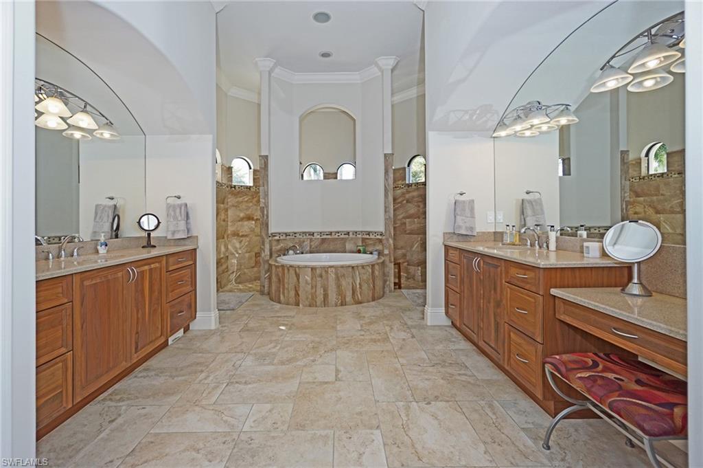 7316 Hagen Way Naples, FL 34113 - Photo 33 of 48 a large bathroom with a double vanity sink a mirror and a bathtub