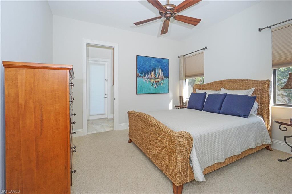 7316 Hagen Way Naples, FL 34113 - Photo 34 of 48 a bedroom with a bed and a chandelier