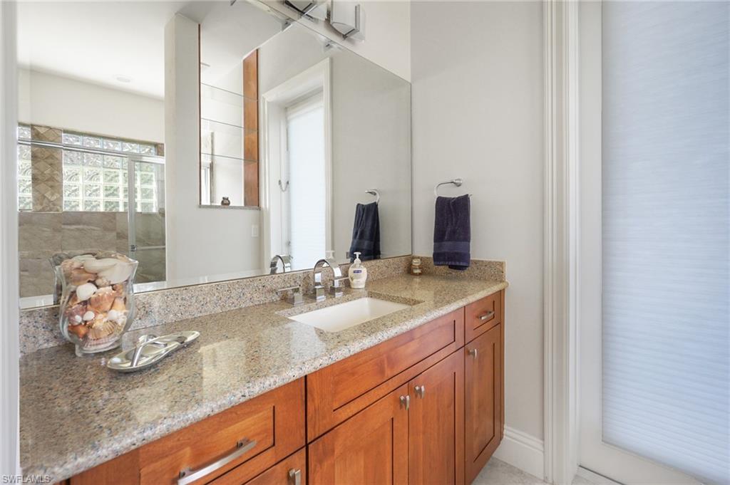 7316 Hagen Way Naples, FL 34113 - Photo 35 of 48 a bathroom with a granite countertop sink and a mirror