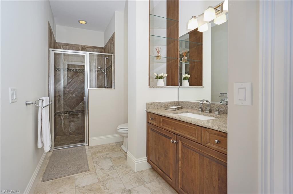 7316 Hagen Way Naples, FL 34113 - Photo 37 of 48 a spacious bathroom with a granite countertop sink a toilet and shower