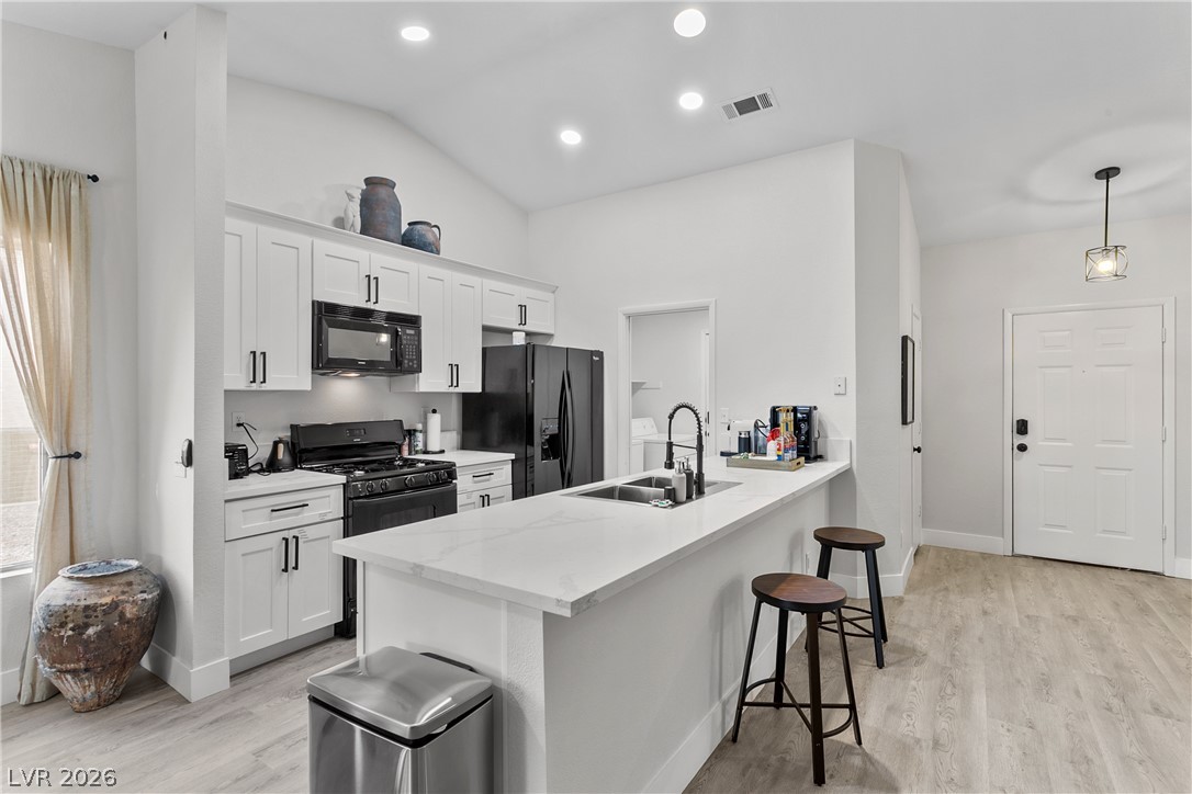 101 Beaver Ridge Avenue North Las Vegas, NV 89031 - Photo 10 of 42 Culinary adventures await in this naturally illuminated kitchen, featuring pristine counters and modern black appliances.