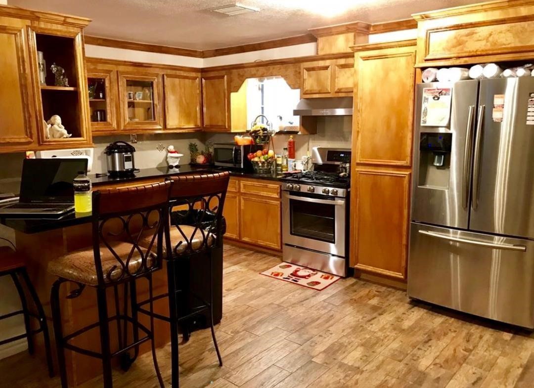 2230 Gault Road Houston, TX 77039 - Photo 12 of 30 a kitchen with stainless steel appliances granite countertop a refrigerator a stove a sink dishwasher a dining table and chairs with wooden floor