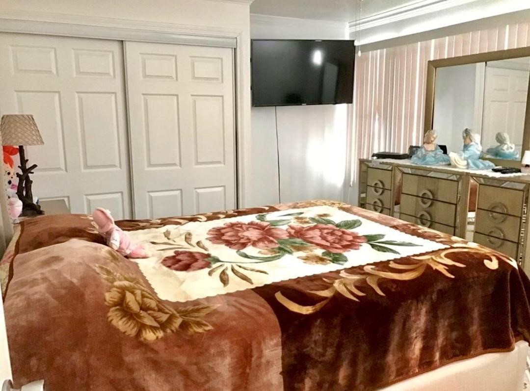 2230 Gault Road Houston, TX 77039 - Photo 16 of 30 a bedroom with a bed a mirror and a flat tv screen