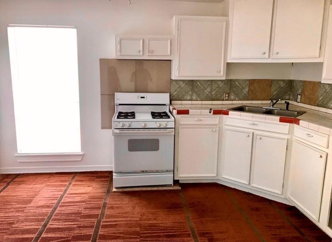 2230 Gault Road Houston, TX 77039 - Photo 25 of 30 a kitchen with a stove top oven and white cabinets