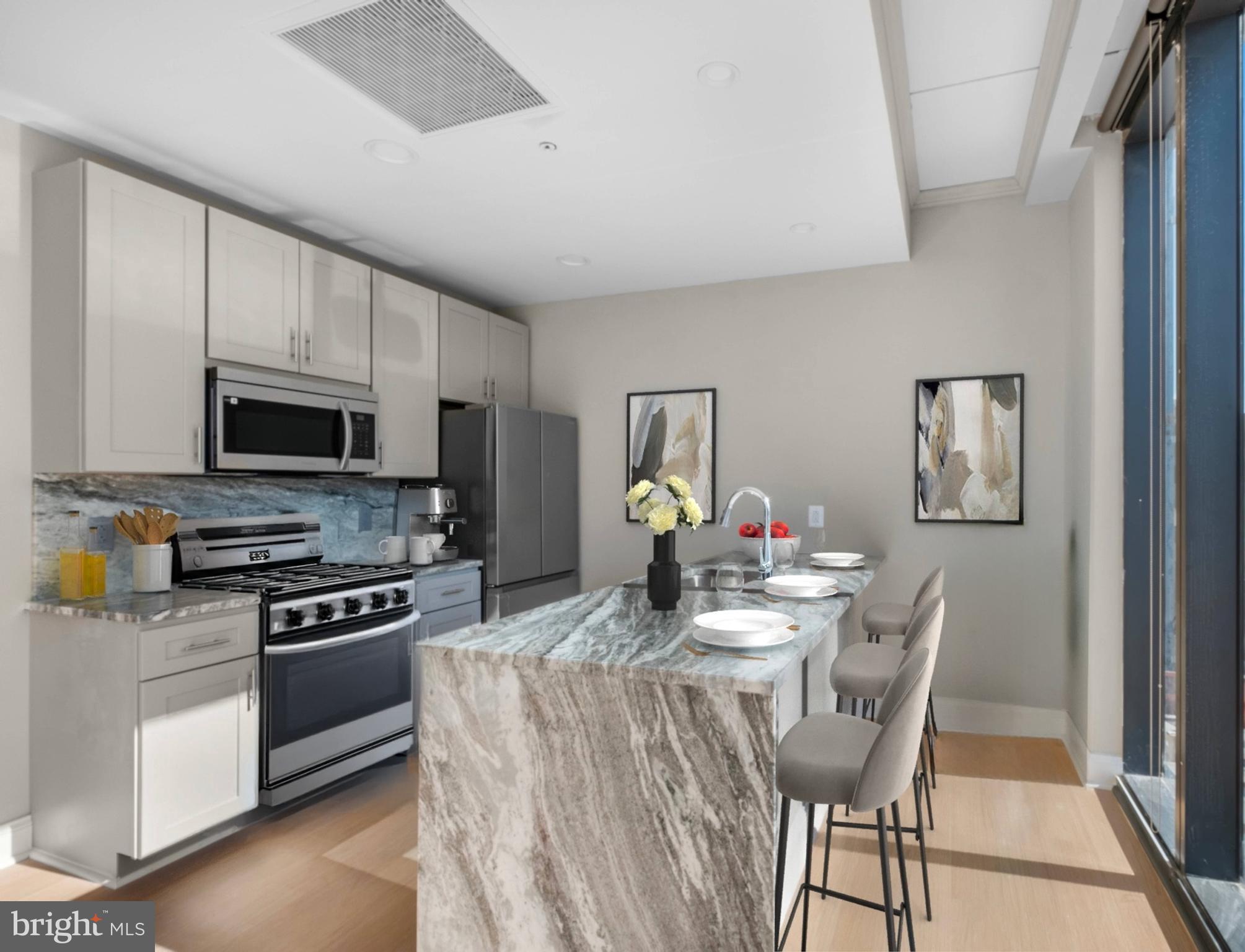 2301-61 John F Kennedy Boulevard, Unit 2113 Philadelphia, PA 19103 - Photo 20 of 43 a kitchen with stainless steel appliances a kitchen island hardwood floor sink stove dining table and chairs