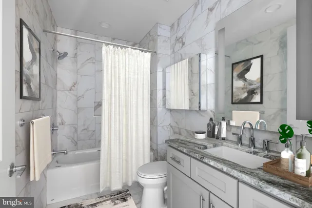 a bathroom with a granite countertop sink a toilet and shower