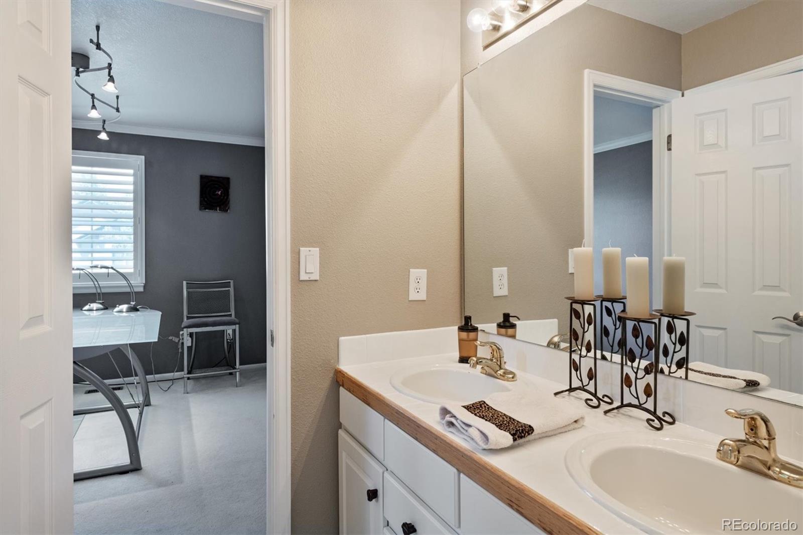9812 South Spring Hill Place Highlands Ranch, CO 80129 - Photo 23 of 27 a bathroom with a double vanity sink a mirror and a bathtub