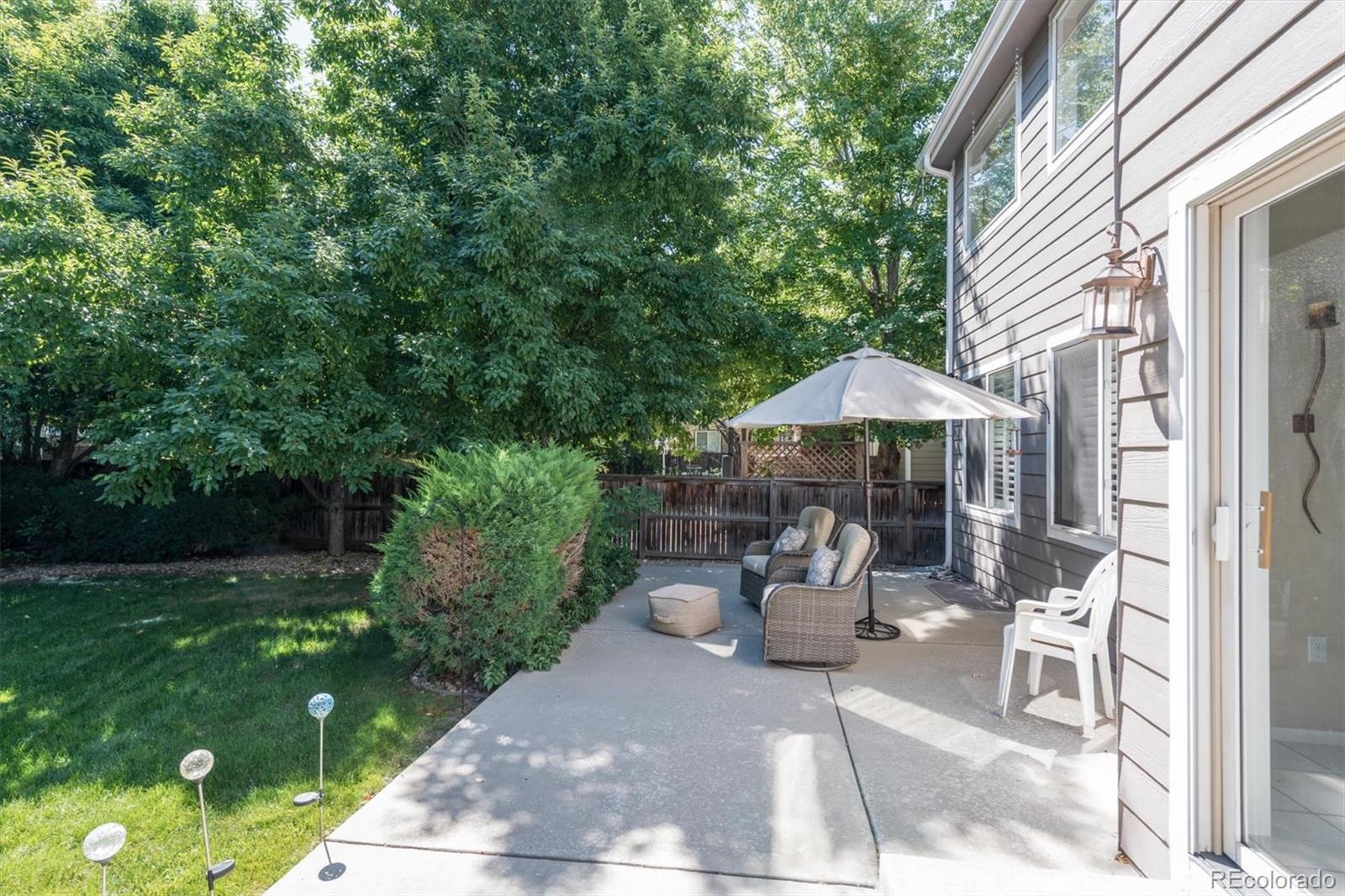 9812 South Spring Hill Place Highlands Ranch, CO 80129 - Photo 24 of 27 a view of a patio with table and chairs under an umbrella