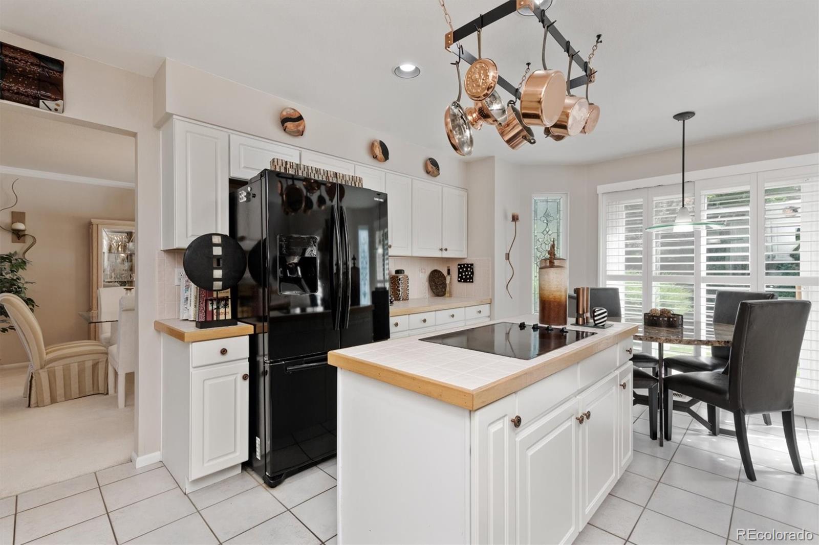 9812 South Spring Hill Place Highlands Ranch, CO 80129 - Photo 7 of 27 a kitchen that has a lot of white cabinets and stainless steel appliances