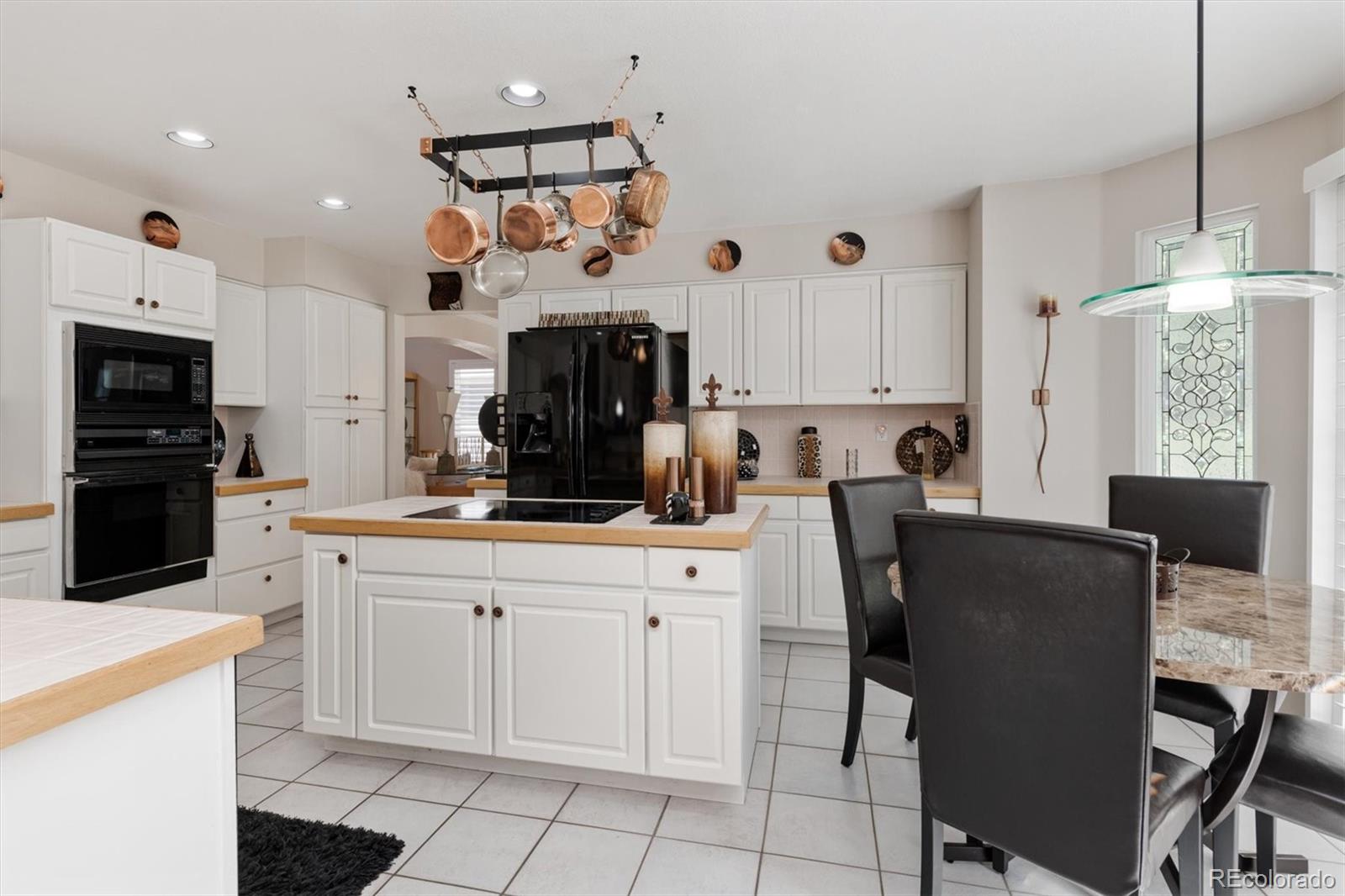 9812 South Spring Hill Place Highlands Ranch, CO 80129 - Photo 8 of 27 a kitchen with cabinets and chairs