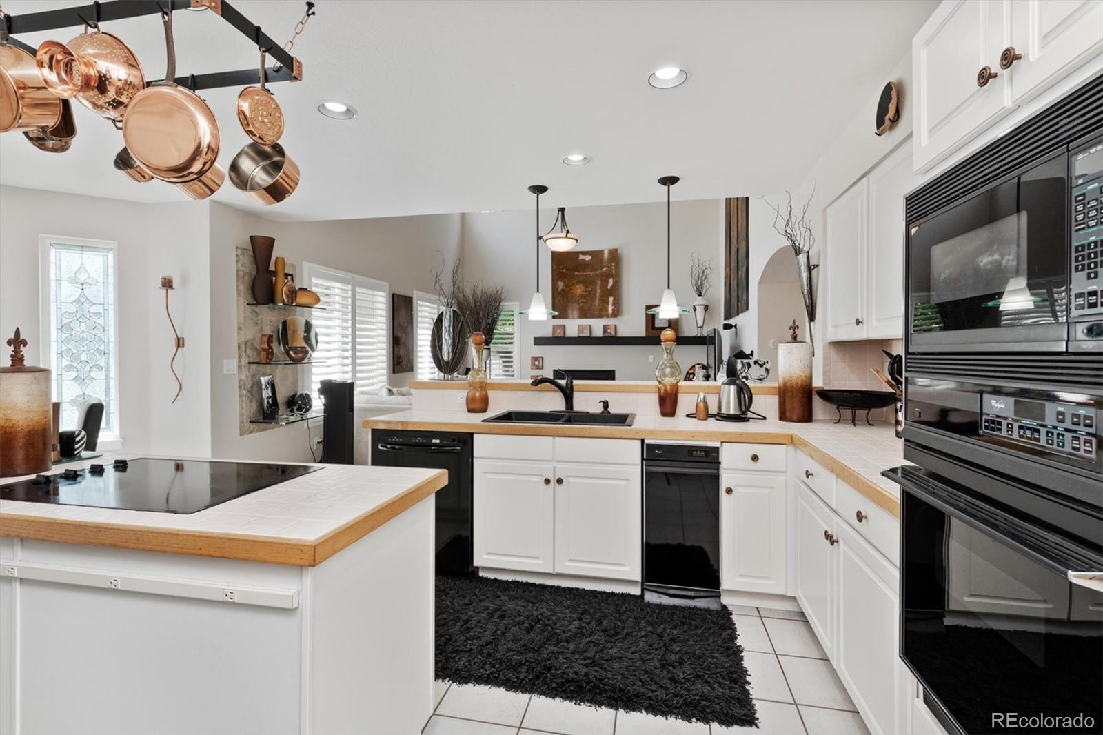 9812 South Spring Hill Place Highlands Ranch, CO 80129 - Photo 9 of 27 a kitchen with stainless steel appliances kitchen island granite countertop a sink and cabinets