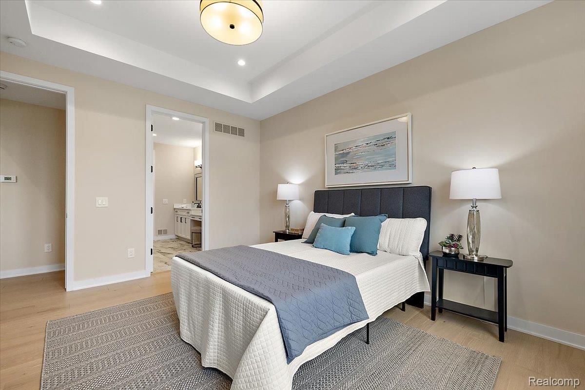 2032 Breckenridge Court, Unit 9 Rochester, MI 48309 - Photo 19 of 39 Bedroom featuring light wood finished floors, a raised ceiling, ensuite bath, and recessed lighting