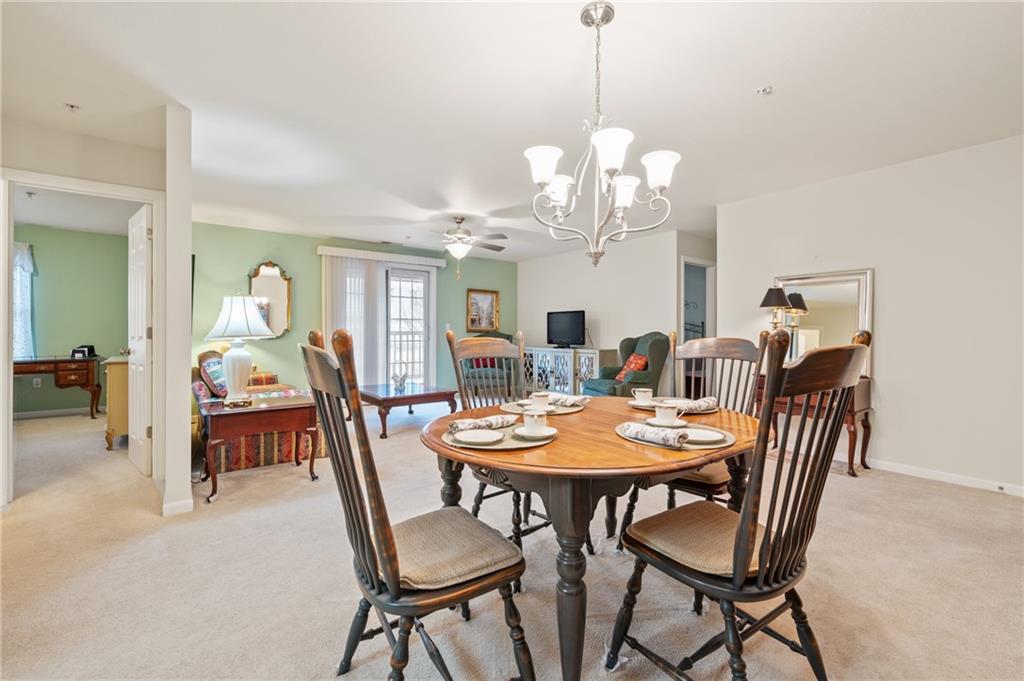 1 Coraopolis Road, Unit 303 Coraopolis, PA 15108 - Photo 14 of 22 a view of a dining room with furniture a chandelier and wooden floor