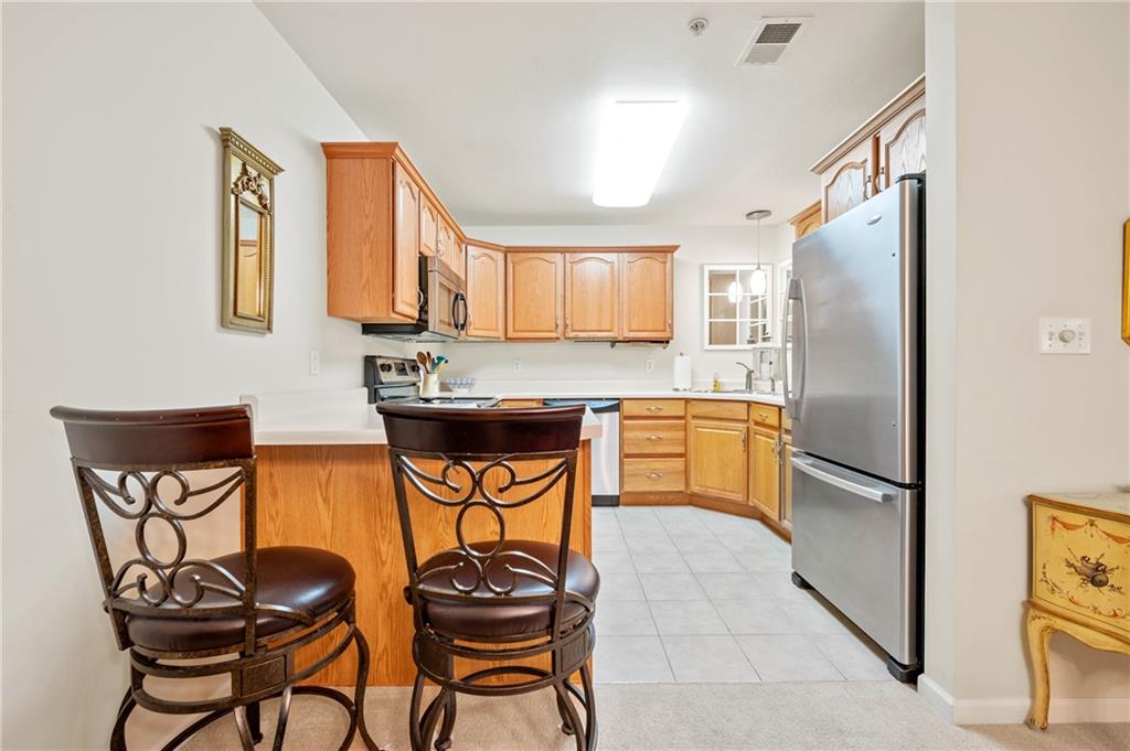 1 Coraopolis Road, Unit 303 Coraopolis, PA 15108 - Photo 8 of 22 a kitchen with stainless steel appliances granite countertop a refrigerator and a stove top oven