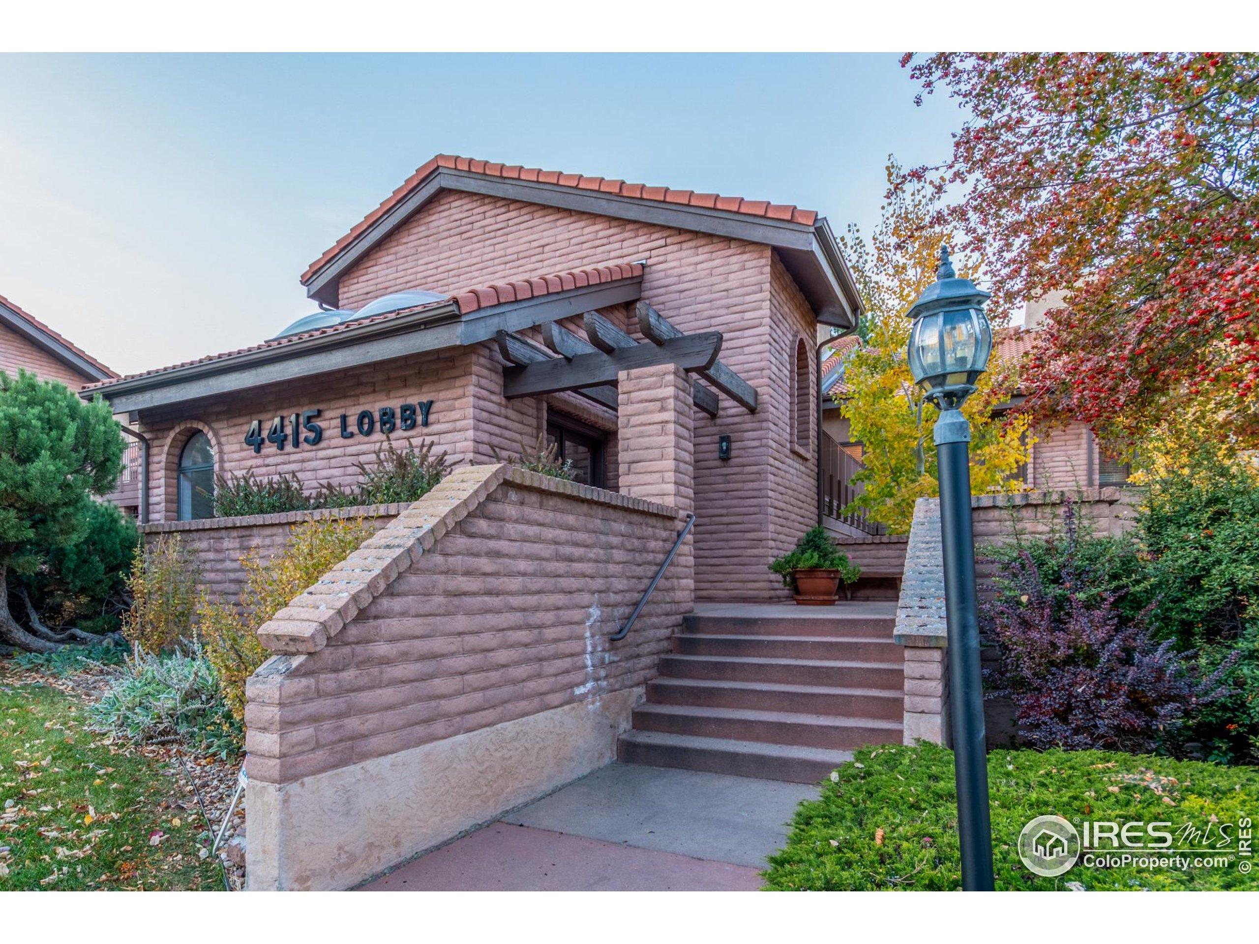 4415 Laguna Place, Unit 201 Boulder, CO 80303 - Photo 2 of 38 a view of a brick house with large windows and a small yard