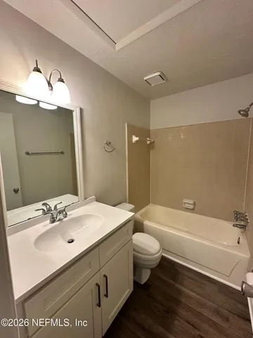 a bathroom with a tub sink toilet and a mirror