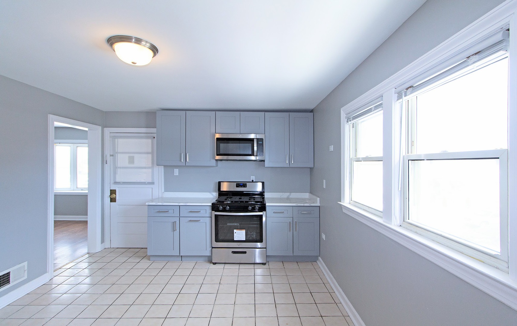 7535 West 58th Place Summit, IL 60501 - Photo 13 of 34 a kitchen with stainless steel appliances a stove a sink and a window