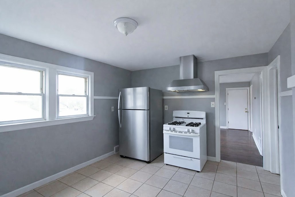 7535 West 58th Place Summit, IL 60501 - Photo 18 of 34 a kitchen with a refrigerator a stove top oven and cabinets