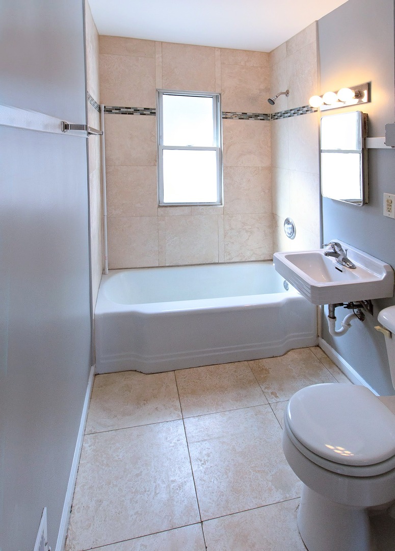 7535 West 58th Place Summit, IL 60501 - Photo 23 of 34 a bathroom with a sink a toilet a mirror and bathtub