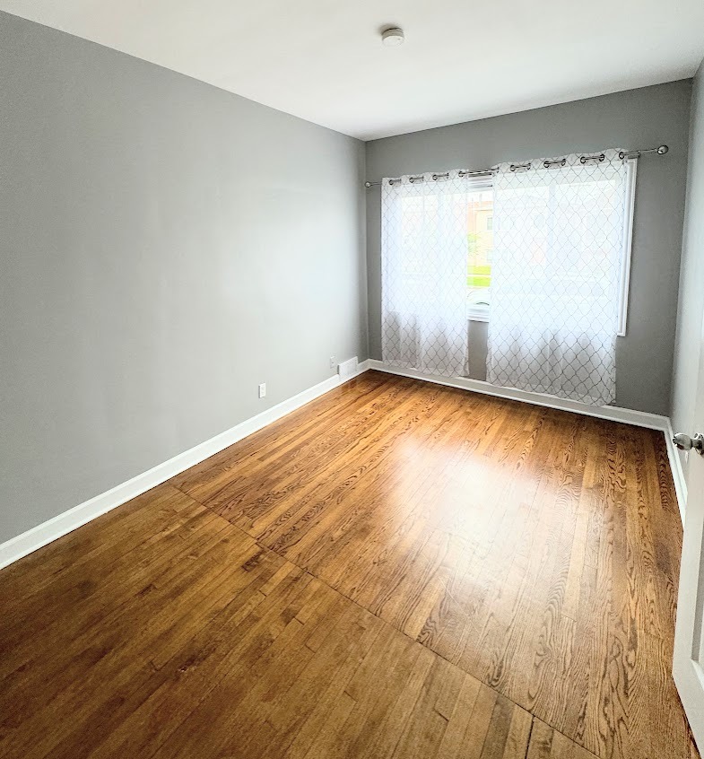 7535 West 58th Place Summit, IL 60501 - Photo 8 of 34 an empty room with wooden floor and windows
