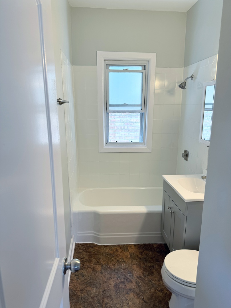 7535 West 58th Place Summit, IL 60501 - Photo 9 of 34 a bathroom with a toilet a sink and a bathtub