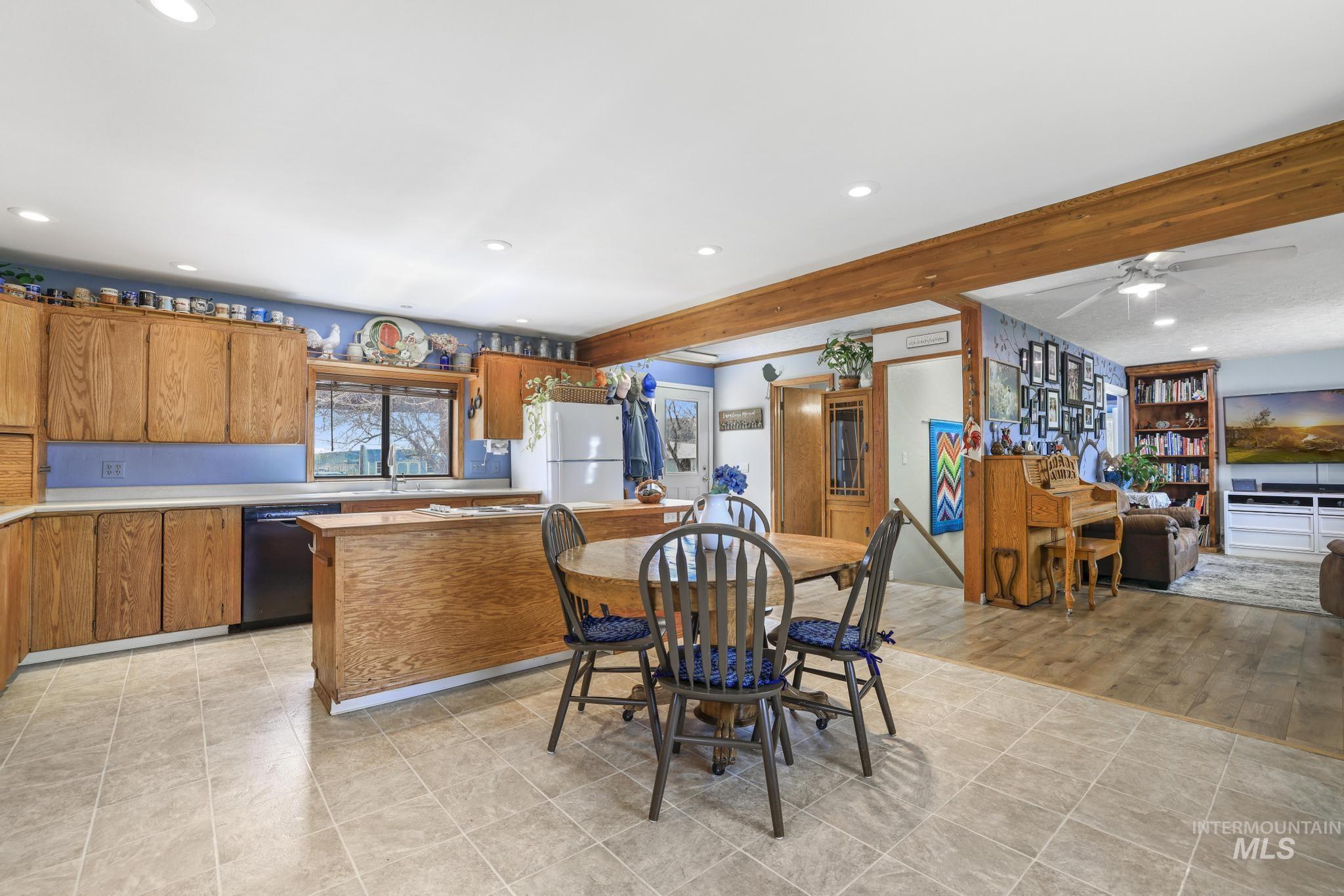 19591 Queen Crown Road Carey, ID 83320 - Photo 6 of 37 Bright kitchen featuring wood cabinetry, a central island, and tile flooring