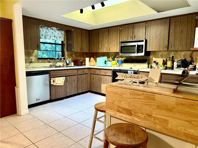 a kitchen with stainless steel appliances granite countertop a sink dishwasher a stove microwave and cabinets
