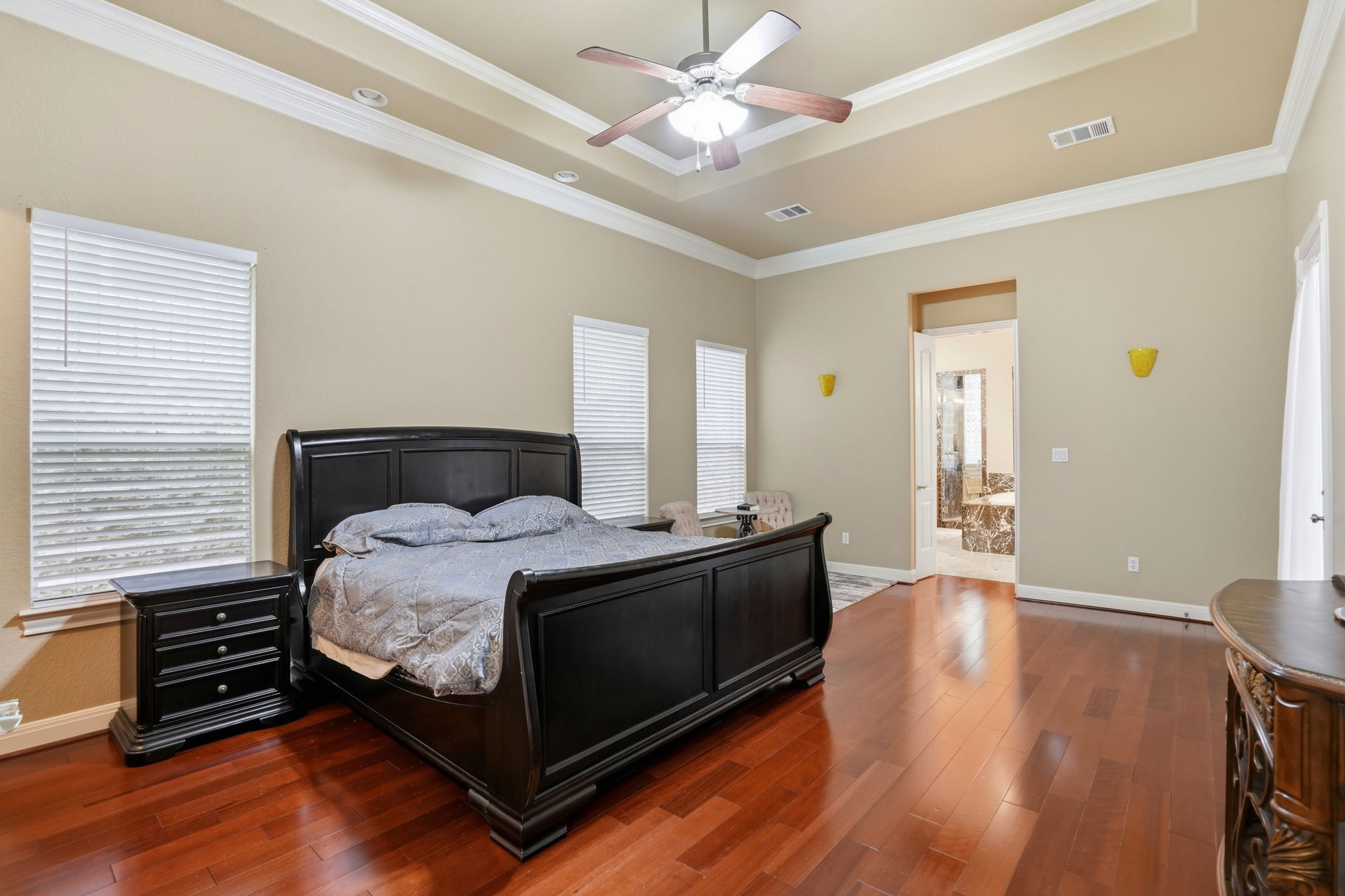 222 Vailco Lane Austin, TX 78738 - Photo 29 of 39 Spacious room featuring wood-finish flooring, a tray ceiling with crown molding, and a ceiling fan