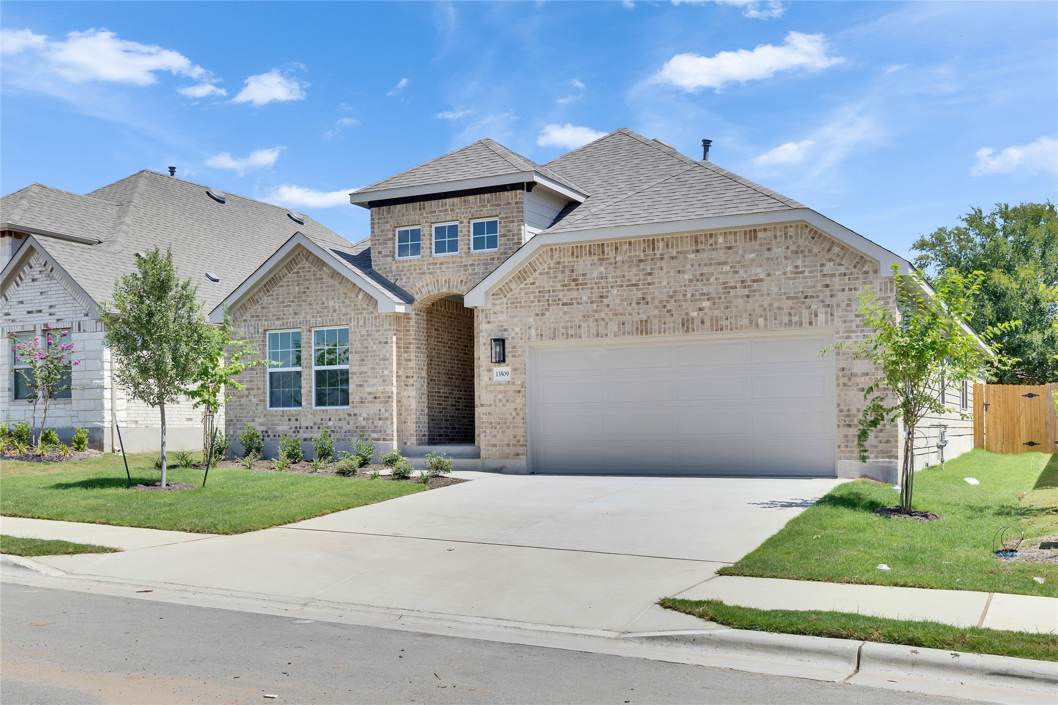 13509 Barn Chime Street Elgin, TX 78621 - Photo 2 of 30 View of front of home with a shingled roof, brick siding, driveway, and an attached garage