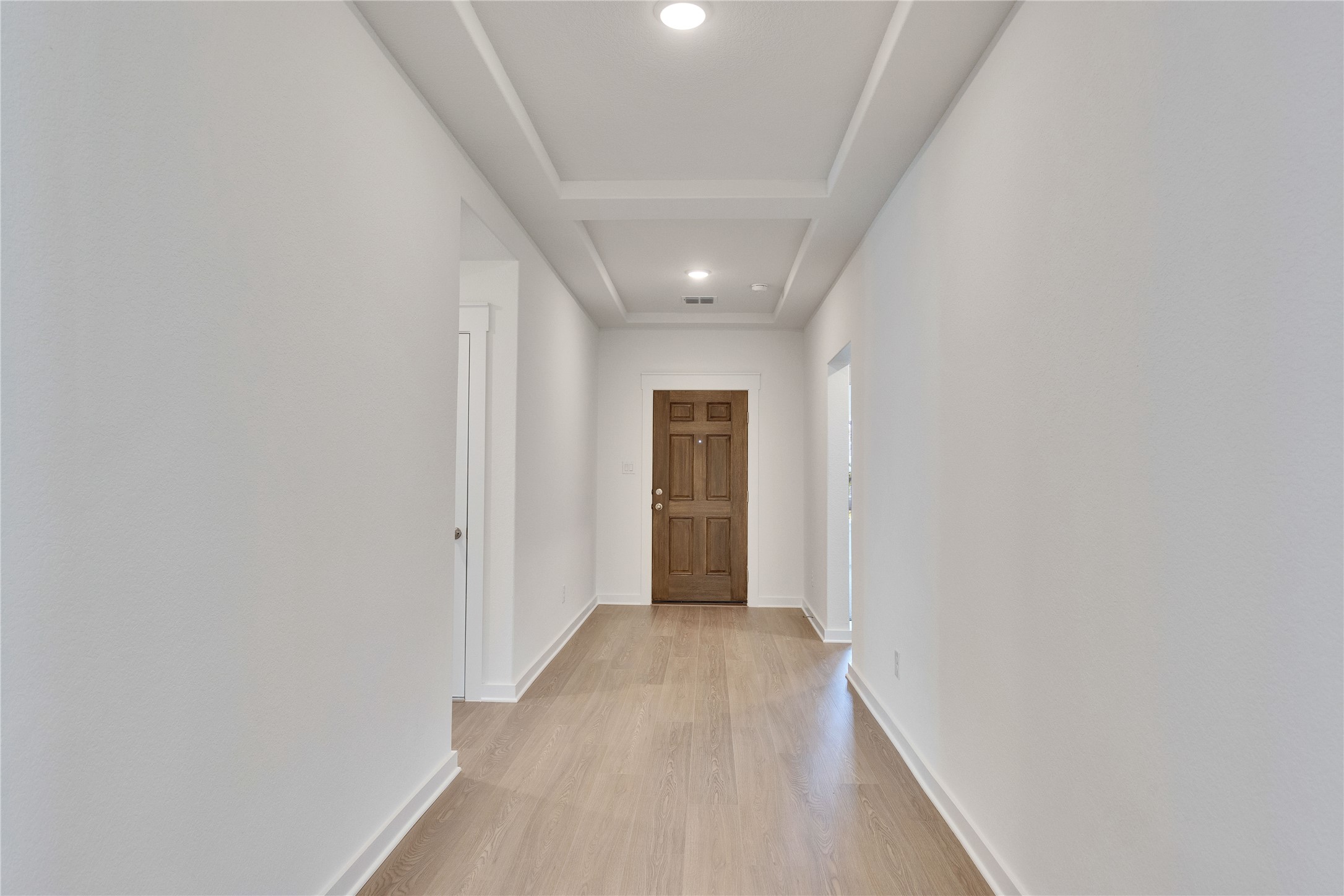 13509 Barn Chime Street Elgin, TX 78621 - Photo 22 of 30 Hall featuring light wood-type flooring, a raised ceiling, and recessed lighting